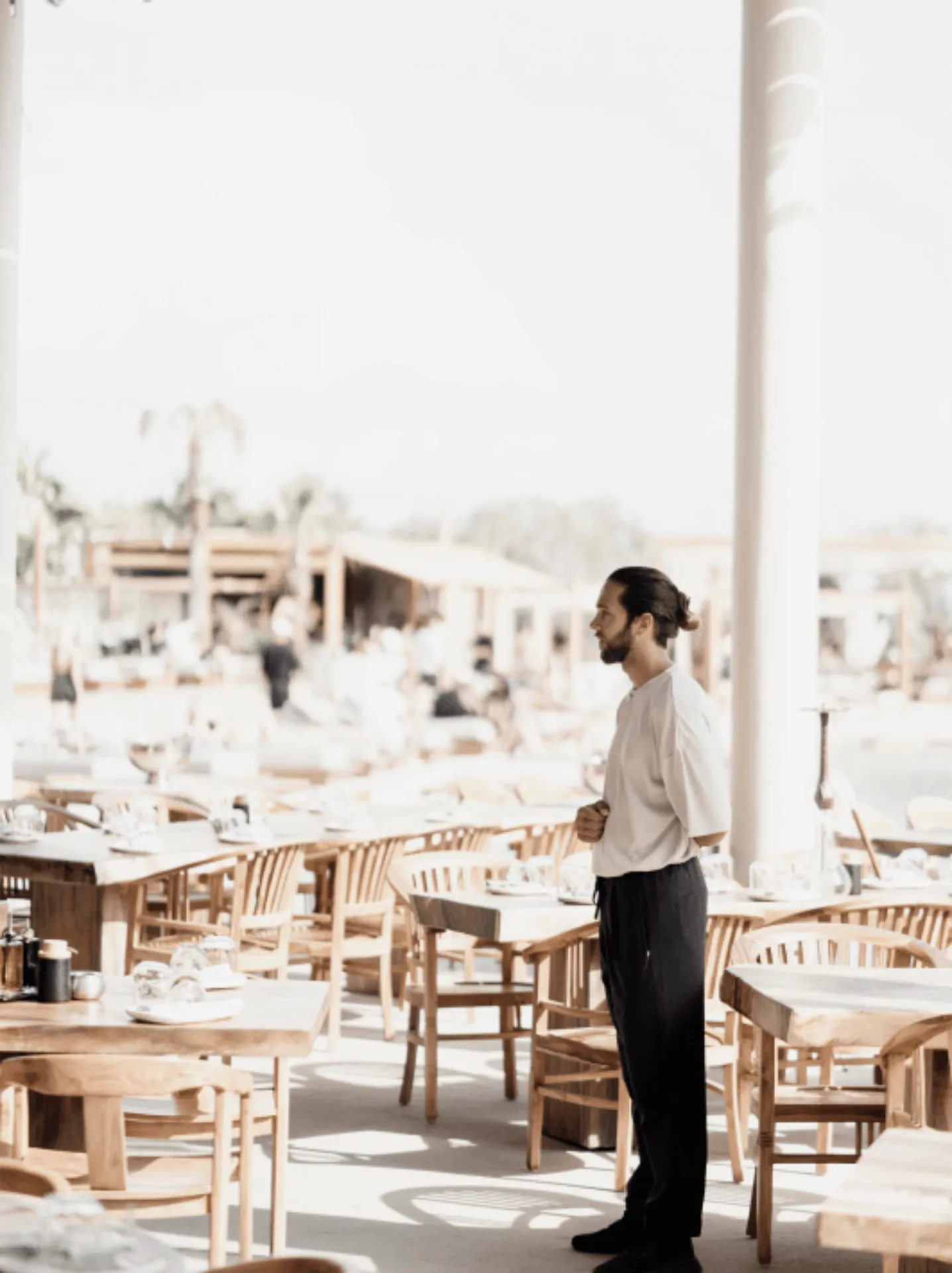 Server in white shirt and black pants surveying the dining area at SantAnna's restaurant.